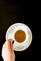 Top View Woman's Hand Holding Coffee Mug on Table