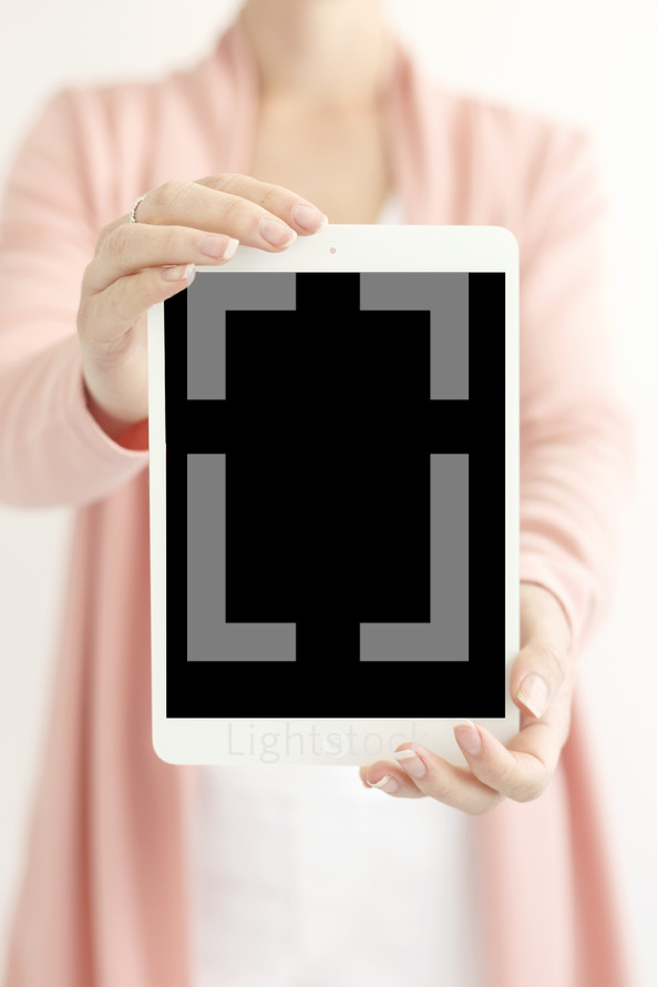 a woman holding up a tablet 