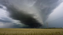 A Dark Storm Cloud Moving Above a Golden Fields of Wheat.