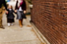 blurry image of people walking on a sidewalk