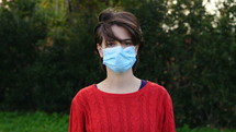 a woman wearing a face mask outdoors 