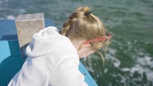 Young Girl Looking Into Moving Water From Boat