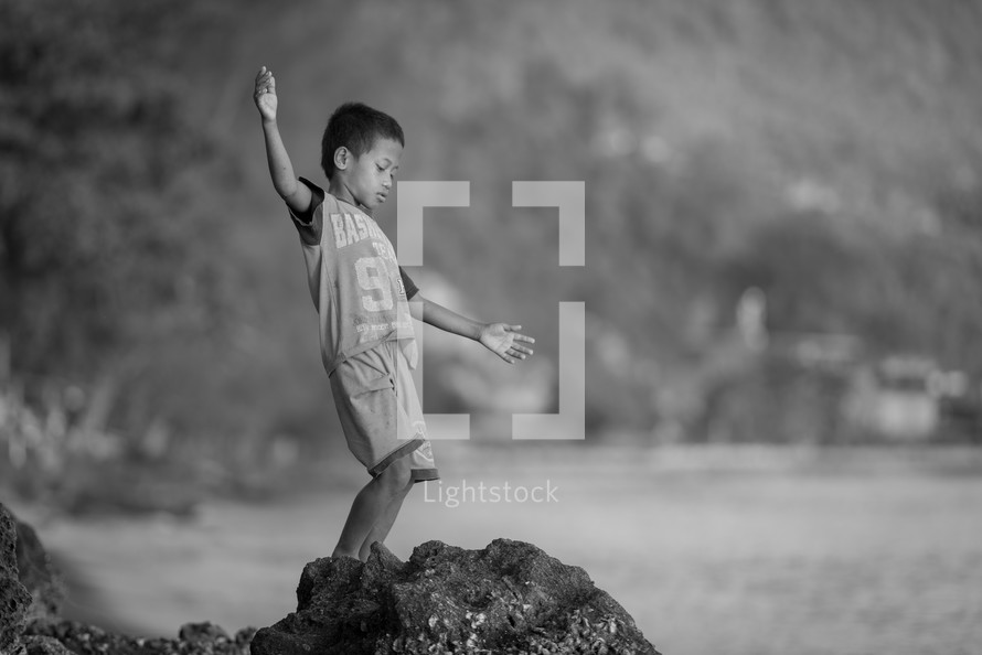 child balancing on a rock 