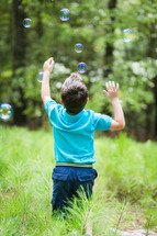 boy chasing bubbles 