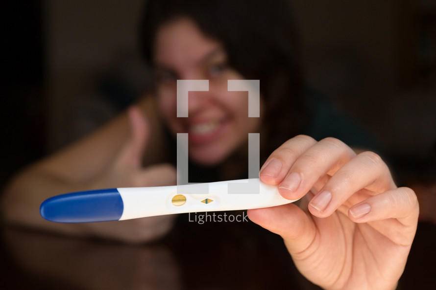 a woman looking at a pregnancy test 