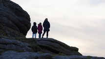 Family Mother Daughter And Son Walking Along Rocks On Dartmoor