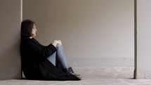 young woman crying sitting on the ground 