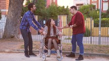 men having a conversation with a woman in a wheelchair 