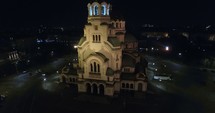 aerial view over a city church and bell tower at night