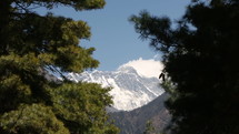 View of Mount Everest peak in distance through trees