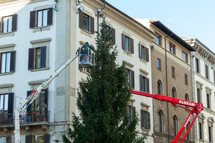 Florence, Italy - December 03, 2023: Christmas tree installation in the central square of Florence. Workers on lifting platforms mount the Christmas lights.