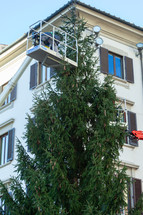 Florence, Italy - December 03, 2023: Christmas tree installation in the central square of Florence. Workers on lifting platforms mount the Christmas lights.