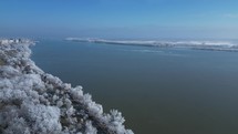 Snow-covered Landscape By The Danube River During Winter In Galati, Romania. aerial pan shot	