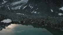 Drone Shot with mountain hiker walking in the background - beautiful reflection