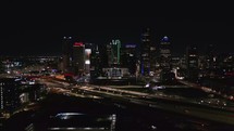 Backwards Aerial of Dallas Skyline at Night	