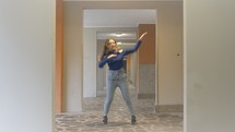 Woman dancing in a hallway.
