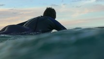Australia male surfer paddling out 