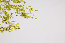 gold sparkle sequins on white background 