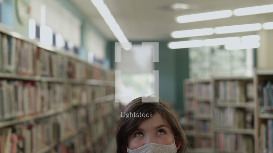 girl at a library wearing a face mask 