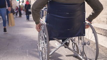 a man in a wheelchair on a sidewalk 