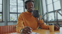 African American Video Blogger Talking at Camera in Recording Studio
