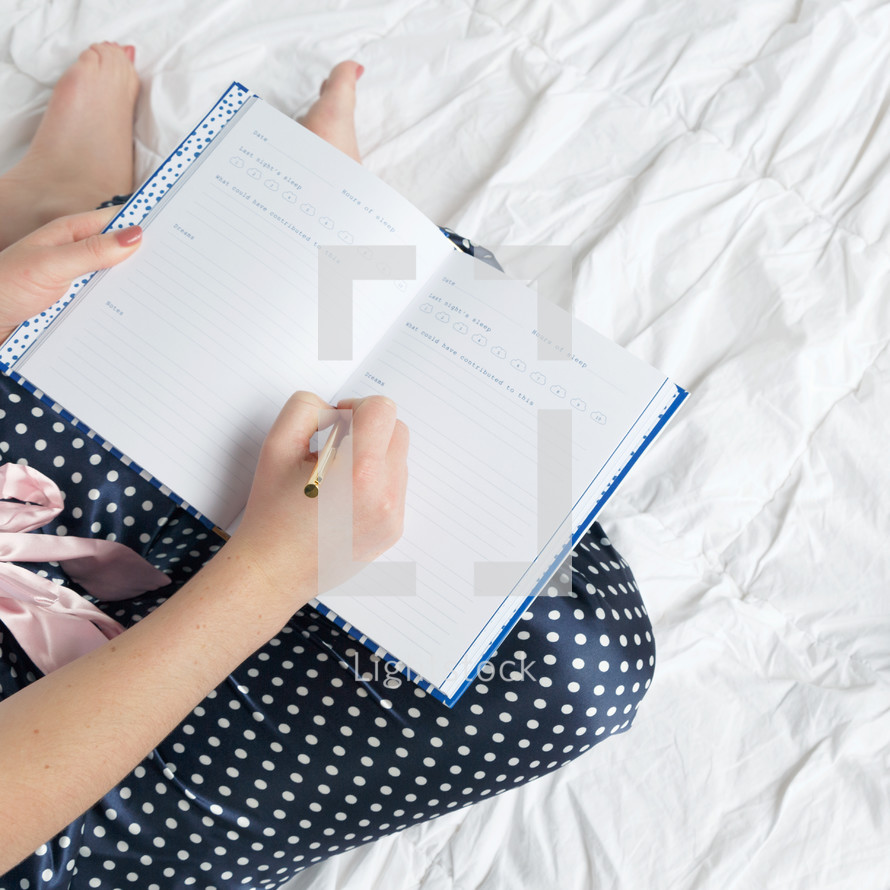 a woman writing in a sleep journal 