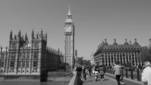 People on Westminster Bridge over River Thames in black and white
