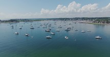 Drone flies over sailboats in a bay