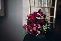 magenta roses in a bouquet in a chair at a wedding 