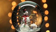 snow globe with a snowman and bokeh lights 