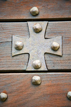 brass cross and a wood door 