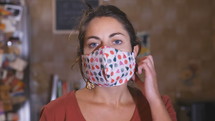 a woman taking off her face mask and smiling 