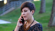 a woman talking on a cellphone outdoors 