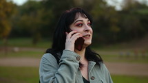 a woman talking on a cellphone outdoors 