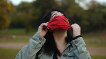 a woman taking off her face mask 