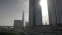 Driving on busy highway with rush hour traffic in city of Dubai in the united Arab emirates with buildings, skyscrapers, skyline in distance.