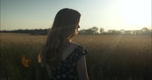 Sun light shines on woman watching sunset in summer nature.