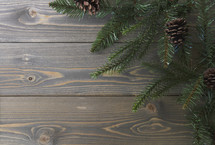 pine branches and pine cones on a wood background 