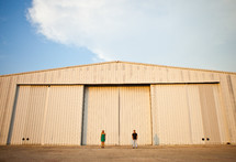 man and woman standing in front of a warehouse