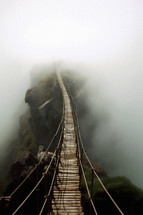 Rope bridge leading into the distant fog