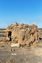 straw and stick hut in a desert 
