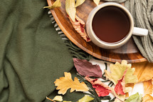 mug, fall leaves on a green scarf 