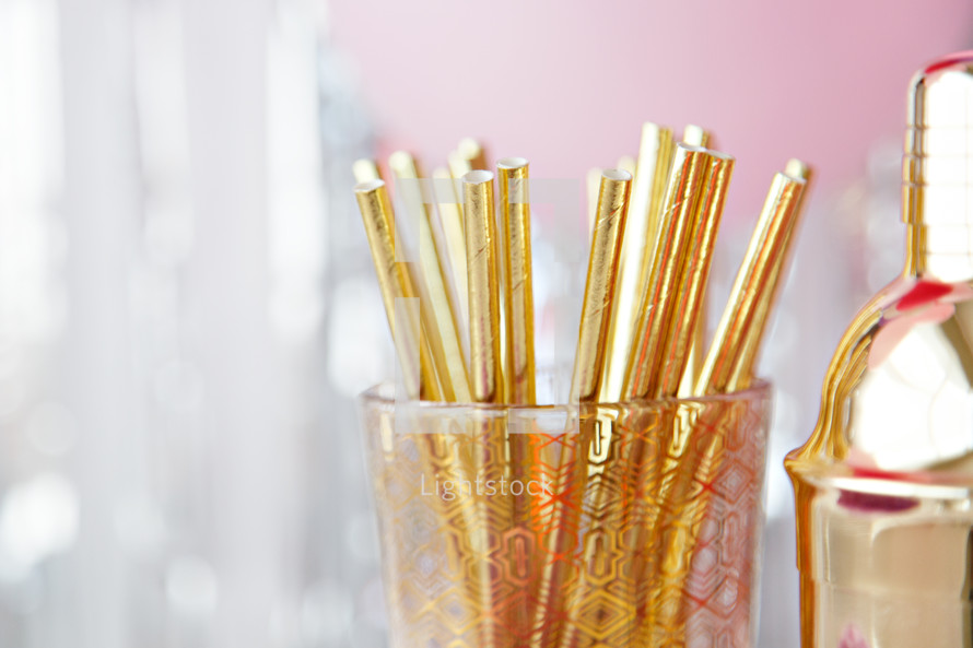 cocktail shaker and gold straws 