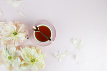 spoon on a tea cup and flower petals 