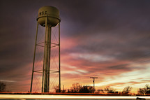 Water tower with stormy night sky in the background.