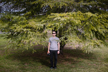 man standing in front of a tree