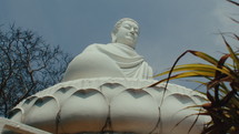 Panorama of a huge Buddha statue sitting in the middle of the jungle. Dolly shot