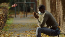 a man praying alone outdoors 