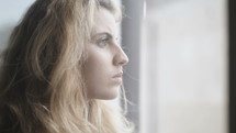 a young woman looking out a window 