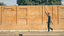 a blind man walking with a guide stick 